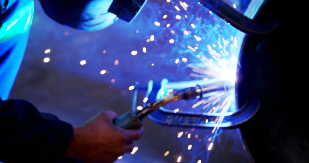 Welder in Protective Gear Working with Sparks and Blue Light - Free Images, Stock Photos and Pictures on Pikwizard.com