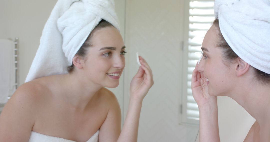 Woman in Bathroom Wearing Towel Applying Skincare Product - Free Images, Stock Photos and Pictures on Pikwizard.com