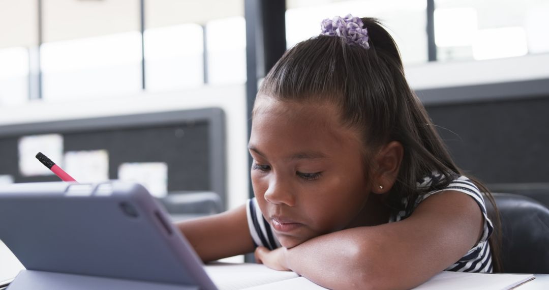 Focused Young Girl Using Tablet in Classroom Learning Environment