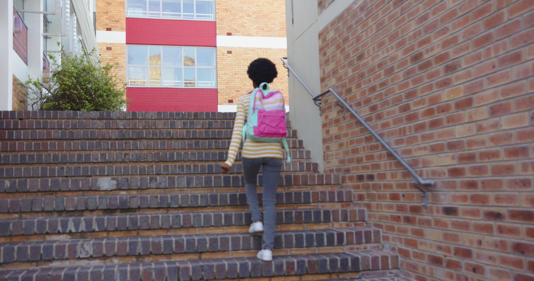 Student Climbing Campus Stairs with Backpack in Urban Setting