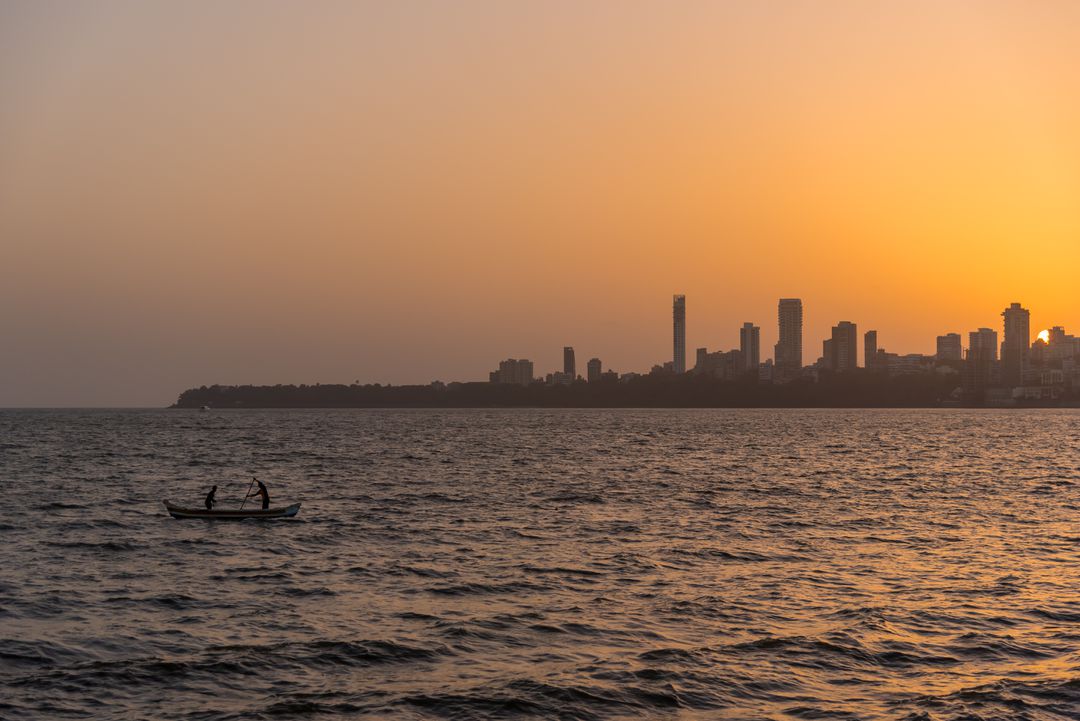 Fishing Boat on Sunset Sea with City Skyline - Free Images, Stock Photos and Pictures on Pikwizard.com