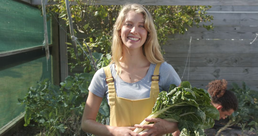 Smiling Young Woman Harvesting Greens in Backyard Garden - Free Images, Stock Photos and Pictures on Pikwizard.com