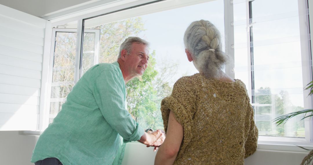 Senior Couple Enjoying Time Together at Home by Window