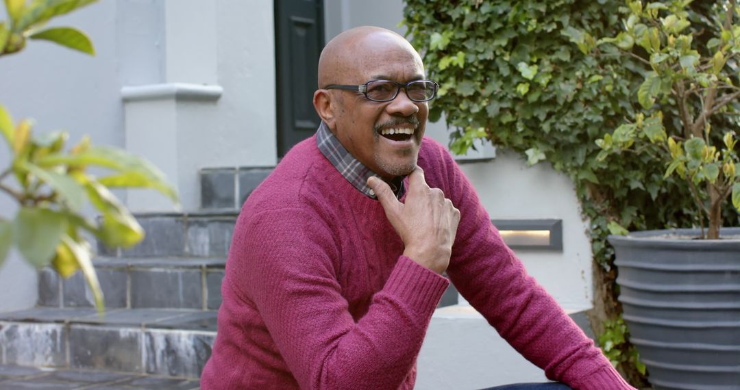 Happy Senior Man Laughing Outdoors at Home Wearing Glasses and Pink Sweater - Free Images, Stock Photos and Pictures on Pikwizard.com