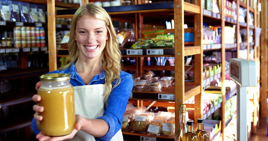 Smiling Woman Displaying Honey Jar in Organic Grocery Store - Free Images, Stock Photos and Pictures on Pikwizard.com