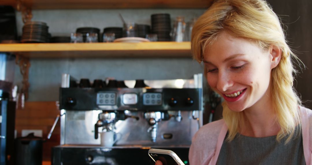 Blonde Woman Smiling While Using Smartphone in Cafe Setting - Free Images, Stock Photos and Pictures on Pikwizard.com