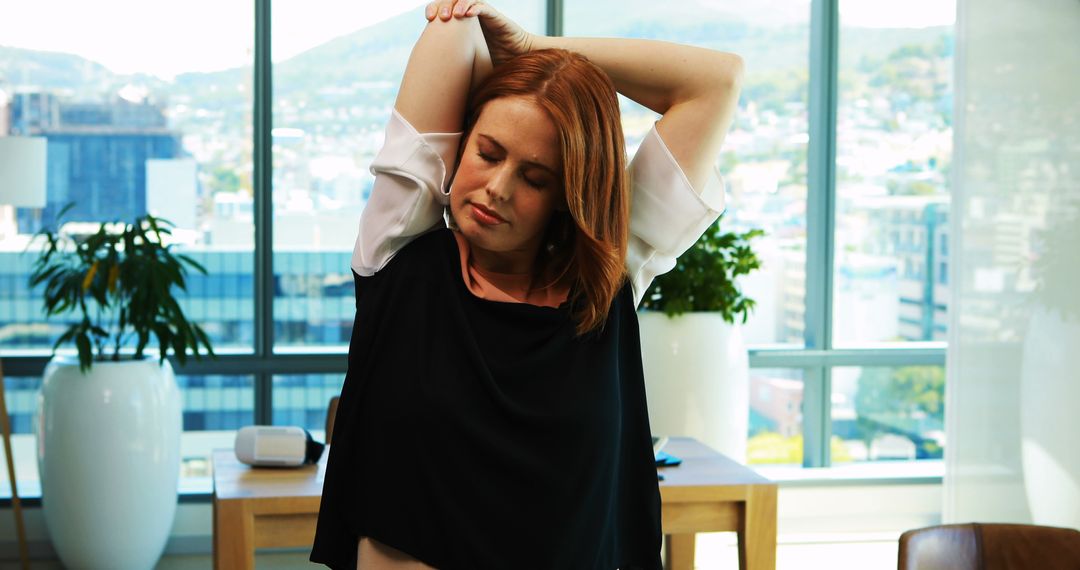 Businesswoman stretching in modern office during break - Free Images, Stock Photos and Pictures on Pikwizard.com