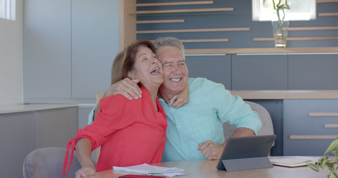 Senior Couple Laughing Together in Home Office with Documents