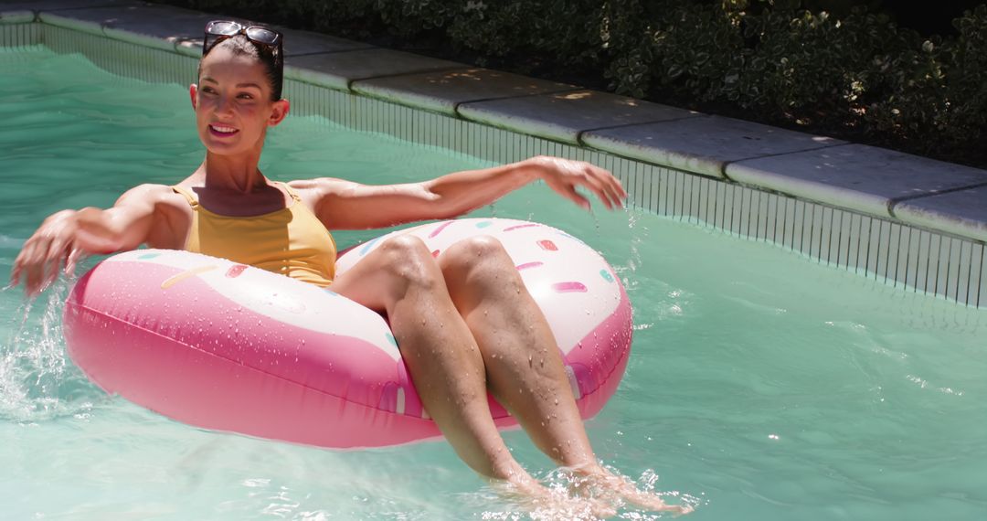 Woman Enjoying Relaxation on Donut Float in Sunny Pool