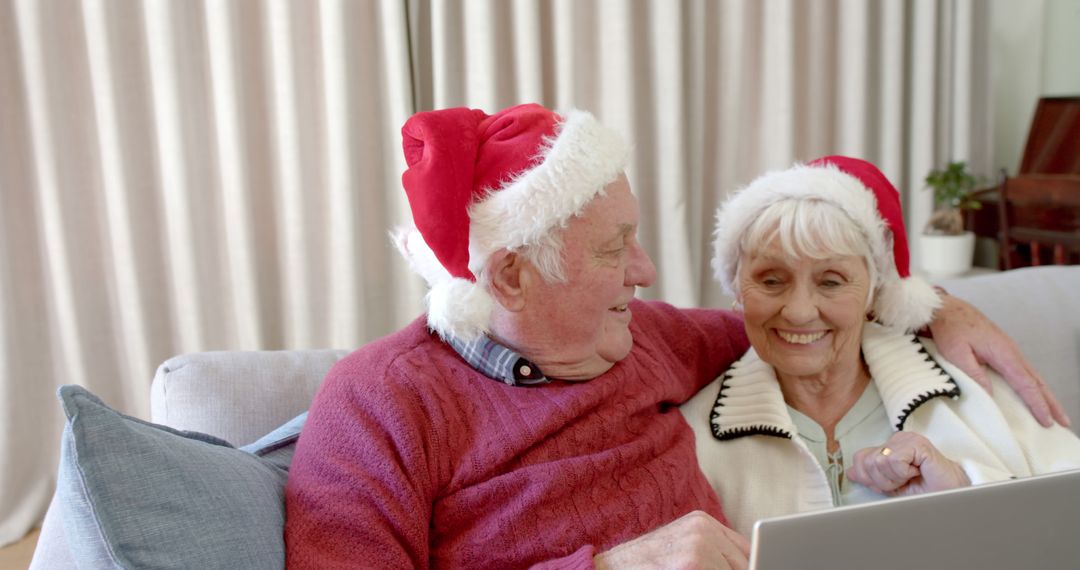 Senior Couple Wearing Santa Hats Enjoying Time on Laptop - Free Images, Stock Photos and Pictures on Pikwizard.com