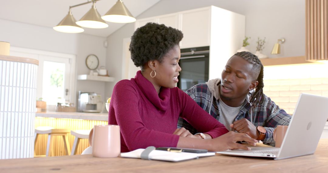 Couple Collaborating In Modern Kitchen Using Laptop