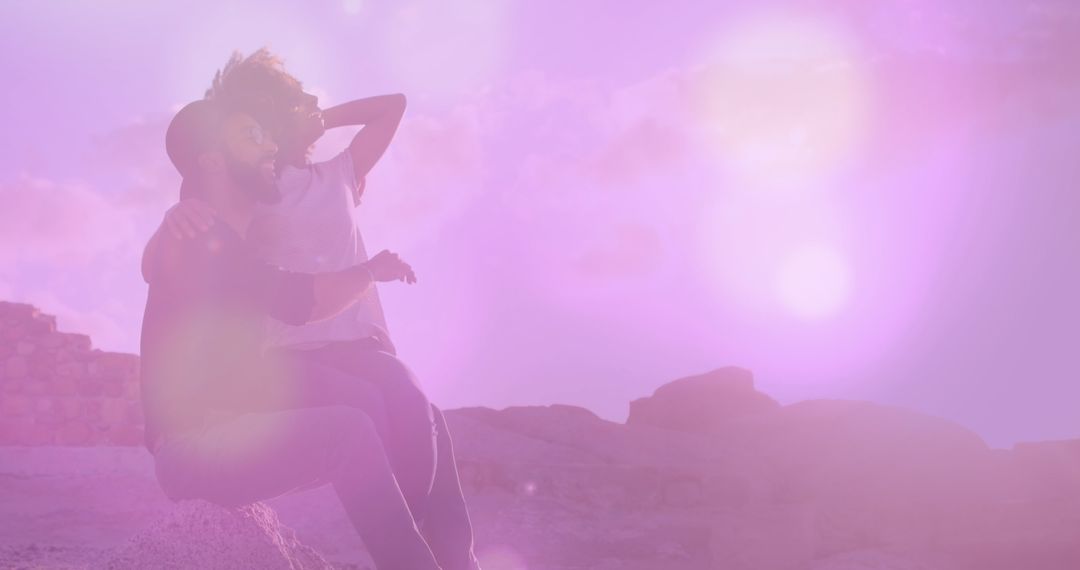 Happy Couple Enjoying Sunset on Beach with Lens Flare