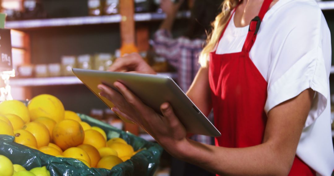 Supermarket Employee Managing Inventory Using Tablet Near Fresh Oranges - Free Images, Stock Photos and Pictures on Pikwizard.com