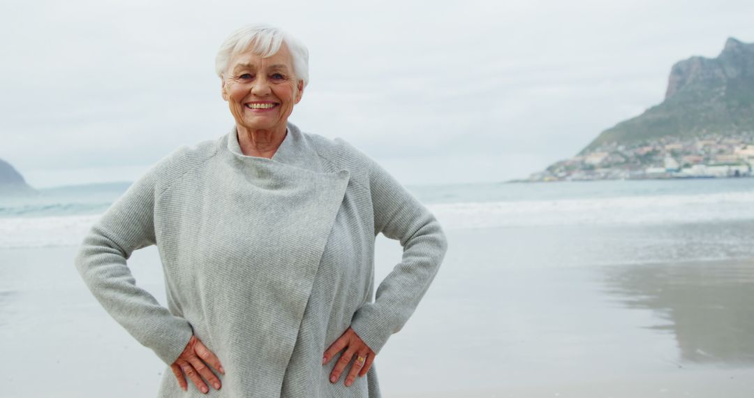 Smiling Elderly Woman in Grey Sweater on Beach - Free Images, Stock Photos and Pictures on Pikwizard.com