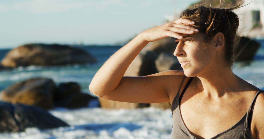 Woman Gazing at Sea Horizon with Hand Shielding Eyes from Sun - Free Images, Stock Photos and Pictures on Pikwizard.com