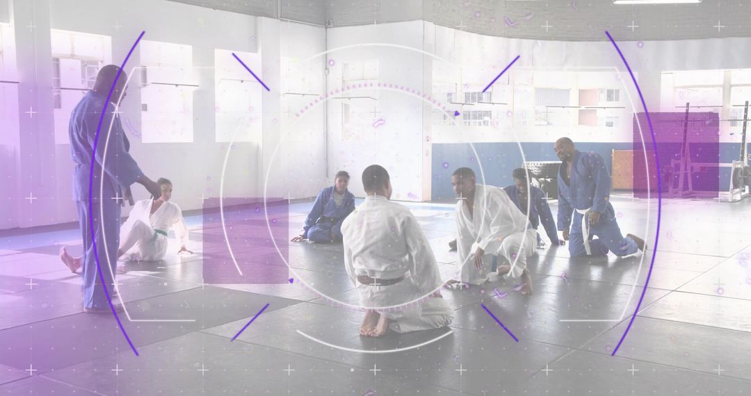 Teaching gi martial arts class with instructor guiding kneeling students on mats