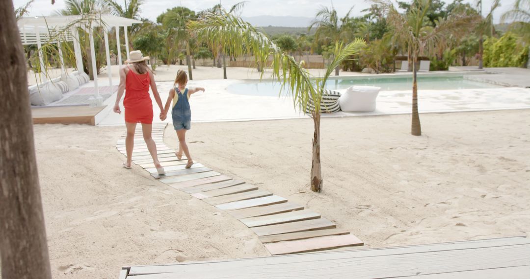 Mother and Daughter Walking to Beach Resort Pool Area - Free Images, Stock Photos and Pictures on Pikwizard.com