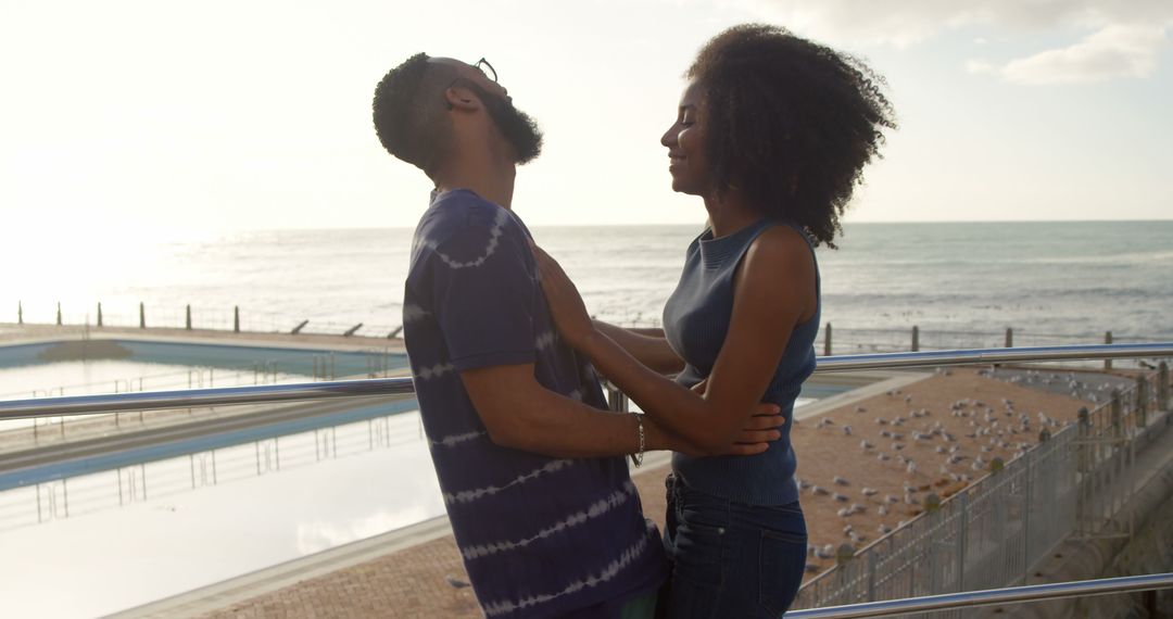 Romantic diverse couple embracing and smiling on sunny beach, copy space - Free Images, Stock Photos and Pictures on Pikwizard.com