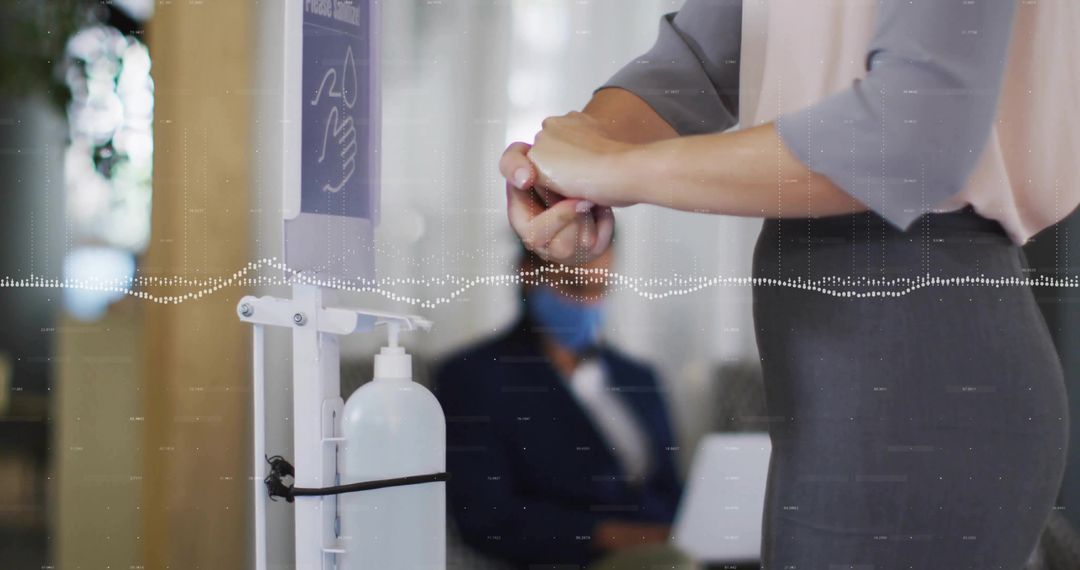 Woman Sanitizing Hands in Office Lobby for Hygiene and Wellness