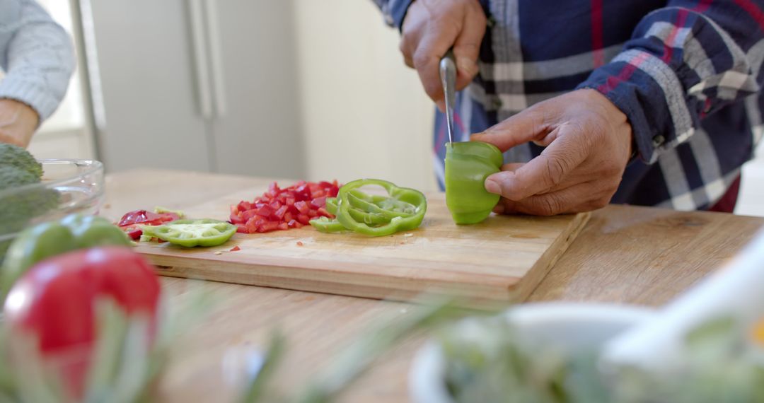 Person chopping green bell pepper on kitchen counter - Free Images, Stock Photos and Pictures on Pikwizard.com