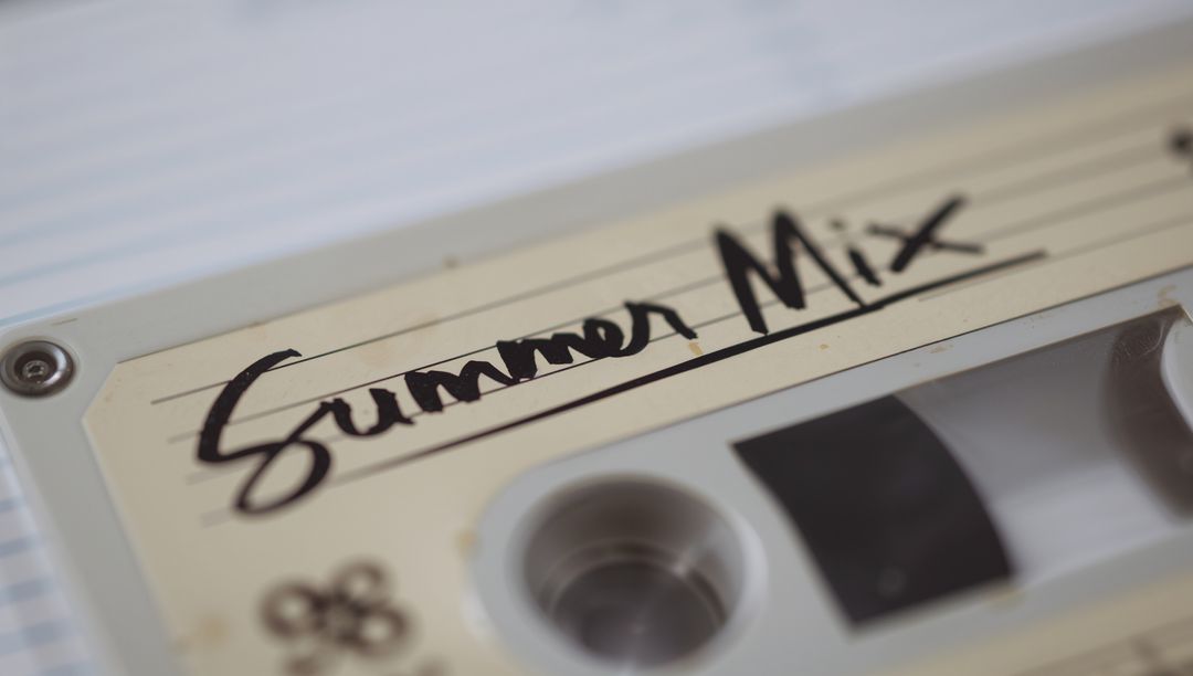 Handwritten Summer Mix Cassette Tape on Ruled Notebook, Retro Analog Nostalgia Closeup