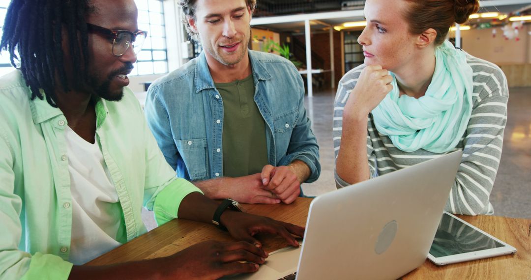 Multiracial Team Discussing Project at Work Over Laptop