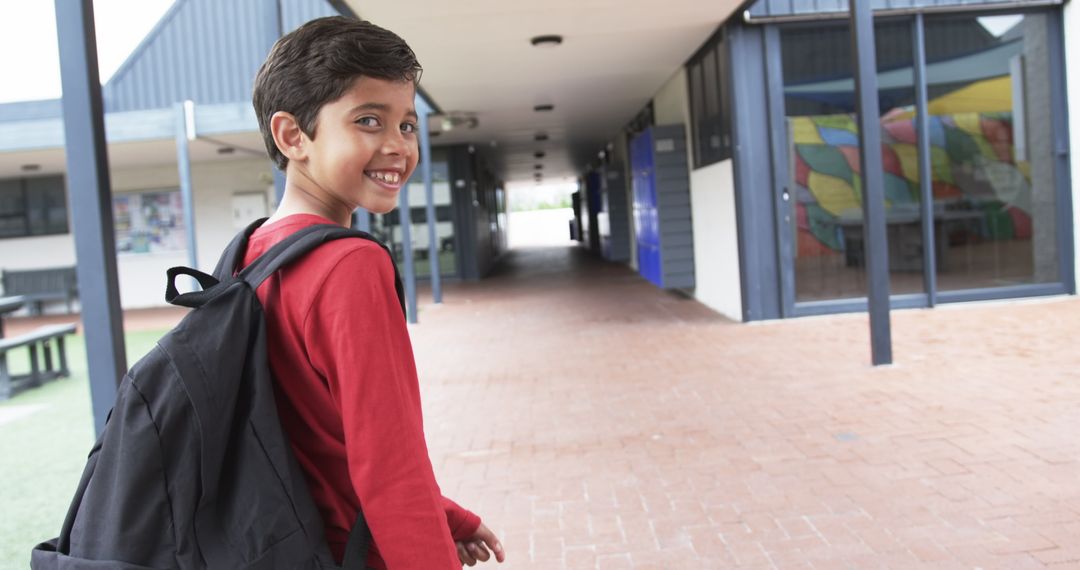Smiling Student Walking in School Corridor with Backpack