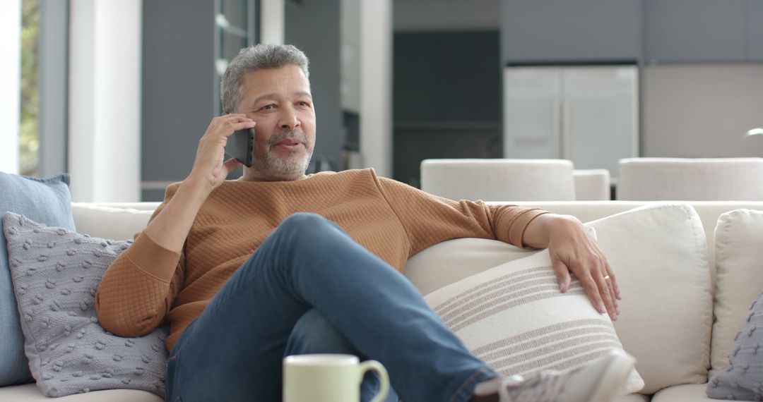 Middle-Aged Man Relaxing on Sofa and Talking on Phone at Home - Free Images, Stock Photos and Pictures on Pikwizard.com