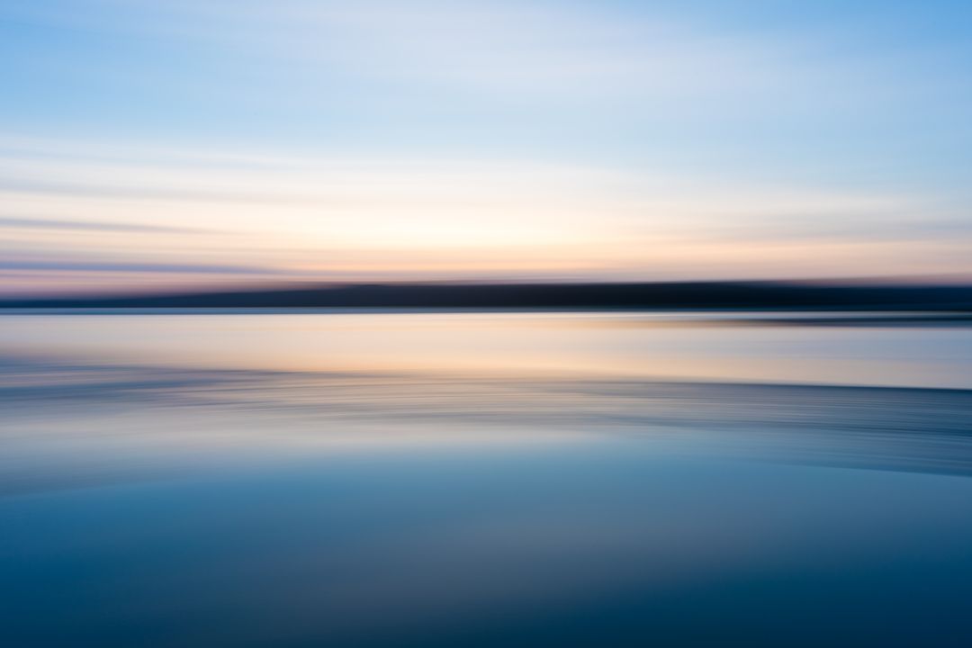 Serene Sunset Over Tranquil Water with Smooth Gradient Sky