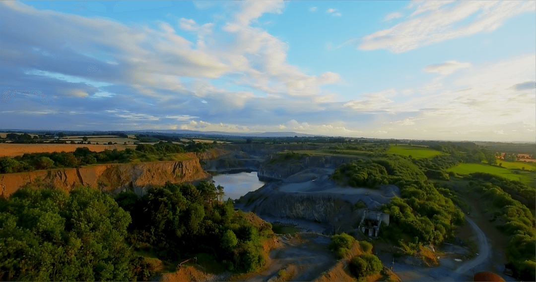 Scenic View of Quarry with Lush Greenery and Calm Waters at Sunset