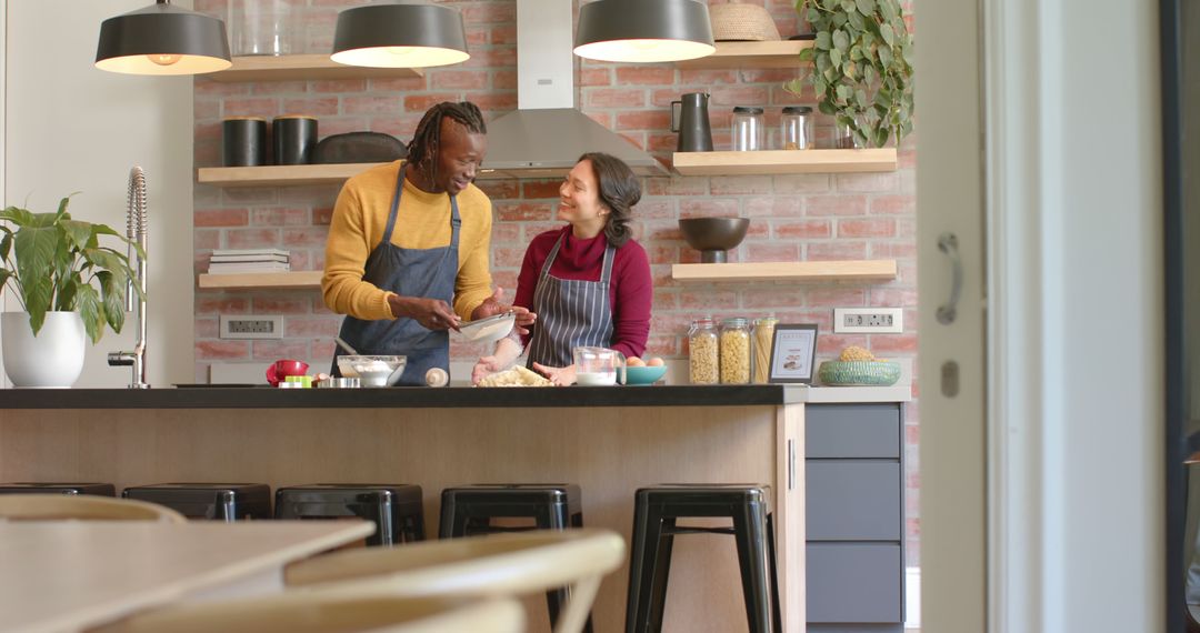 Smiling Couple Cooking Together in Modern Kitchen with Brick Wall - Free Images, Stock Photos and Pictures on Pikwizard.com