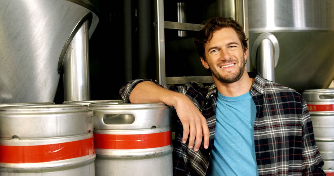 Smiling Brewer Standing in Craft Brewery Next to Stainless Steel Barrels - Free Images, Stock Photos and Pictures on Pikwizard.com