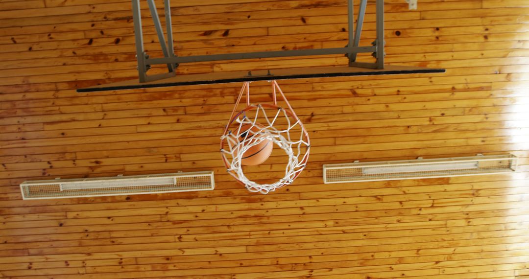 Basketball Swishing Through Hoop in Gymnasium with Wooden Ceiling - Free Images, Stock Photos and Pictures on Pikwizard.com