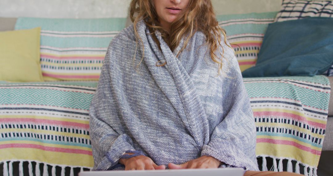 Woman Using Laptop Wrapped in Blanket in Cozy Rustic Setting - Free Images, Stock Photos and Pictures on Pikwizard.com