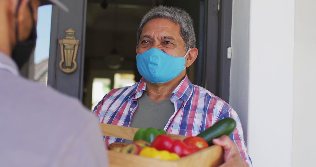 Elderly Man Receiving Grocery Delivery with Facemask During Pandemic - Free Images, Stock Photos and Pictures on Pikwizard.com