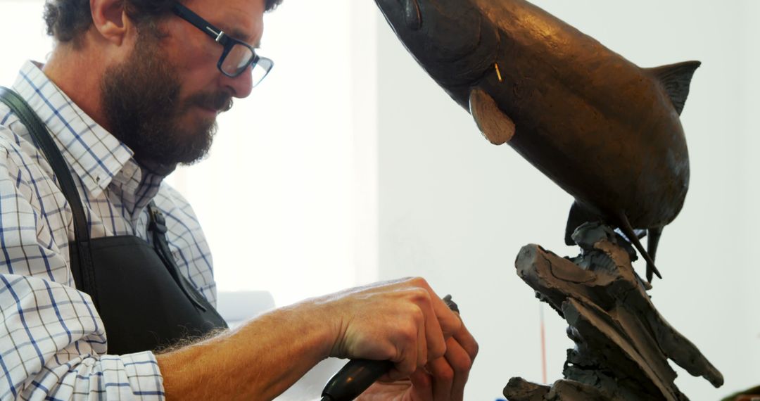 Sculptor Working on Metal Fish Statue in Studio - Free Images, Stock Photos and Pictures on Pikwizard.com