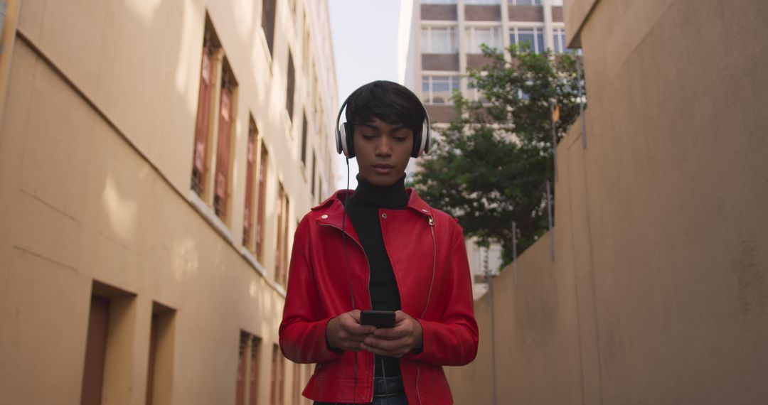 Young Woman in Red Jacket Listening to Music While Using Smartphone - Free Images, Stock Photos and Pictures on Pikwizard.com