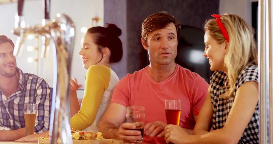 Friends Enjoying Drinks and Pizza in Relaxed Restaurant Setting