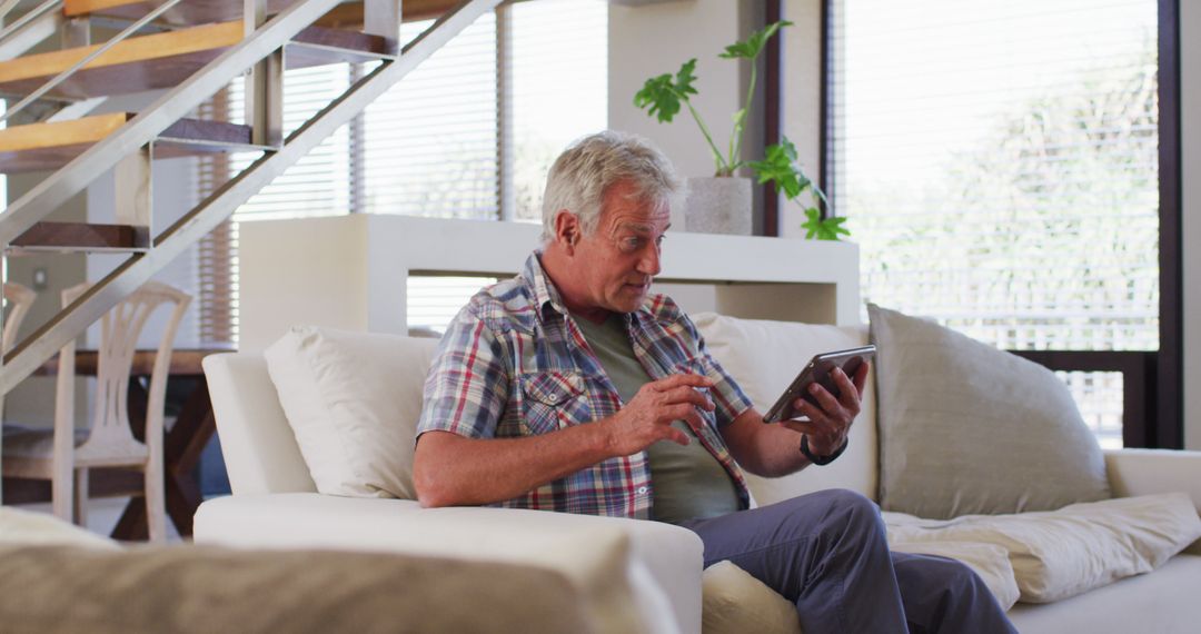 Senior Man Relaxing on Couch Using Digital Tablet at Home - Free Images, Stock Photos and Pictures on Pikwizard.com