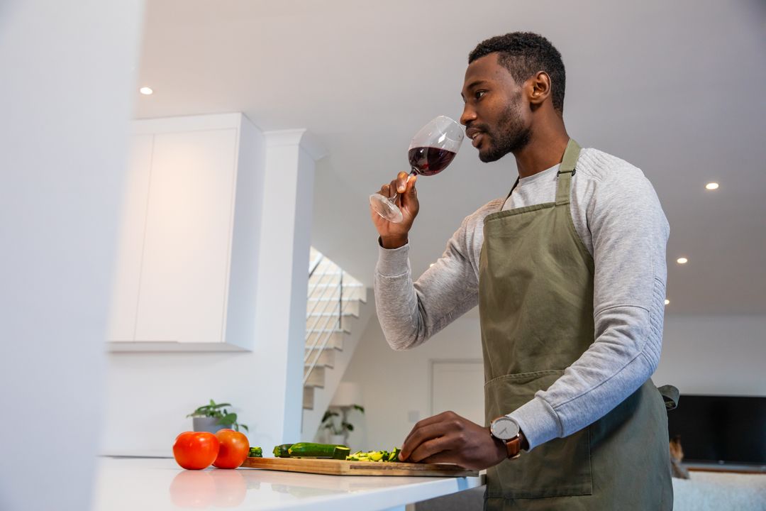 African American Chef Enjoying Red Wine While Cooking in Modern Kitchen