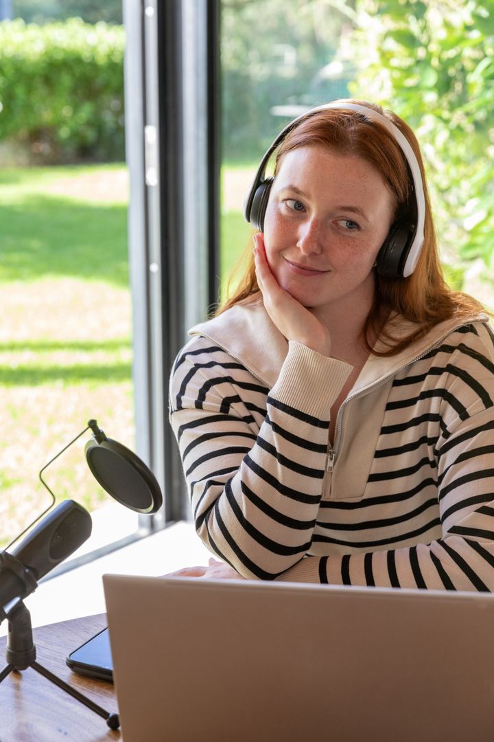 Woman with Headphones Viewing Nature from Home Workspace