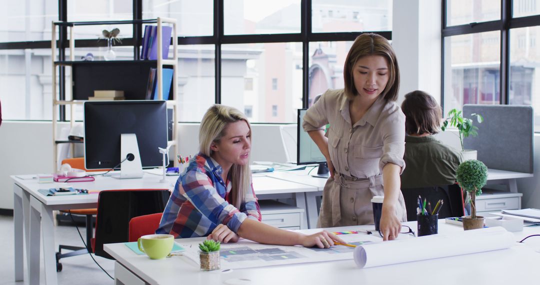 Diverse Female Colleagues Collaborating on Design Project in Office
