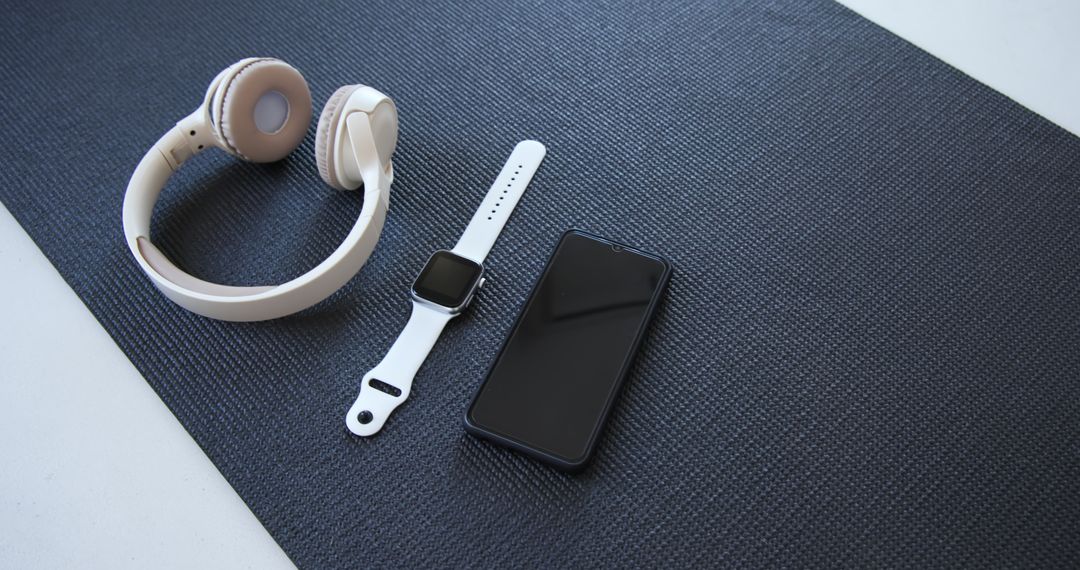 Minimal Tech Setup With Headphones, Smartwatch, and Smartphone