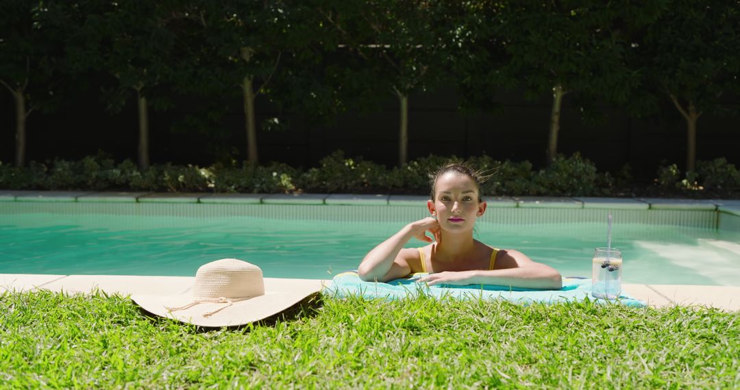 Woman Relaxing in Pool with Summer Essentials
