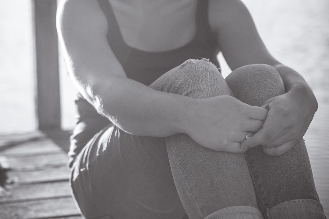 Woman Sitting on Dock by Water in Black and White - Free Images, Stock Photos and Pictures on Pikwizard.com