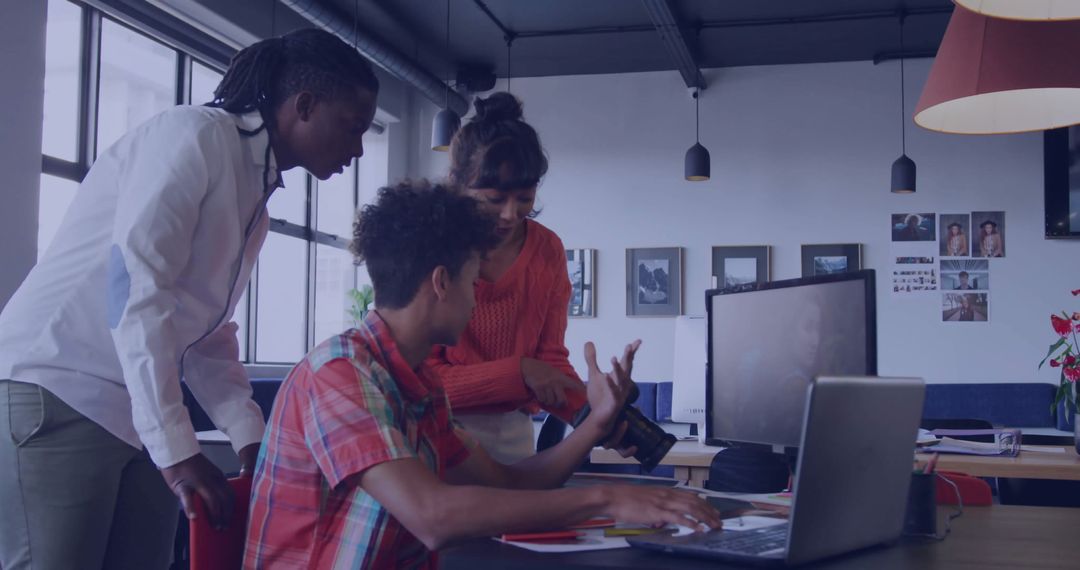 Team Collaborating over DSLR Camera in Modern Office Setting