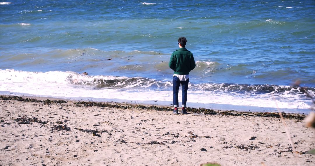 Person Standing on Sandy Beach Looking at Waves Crashing - Free Images, Stock Photos and Pictures on Pikwizard.com