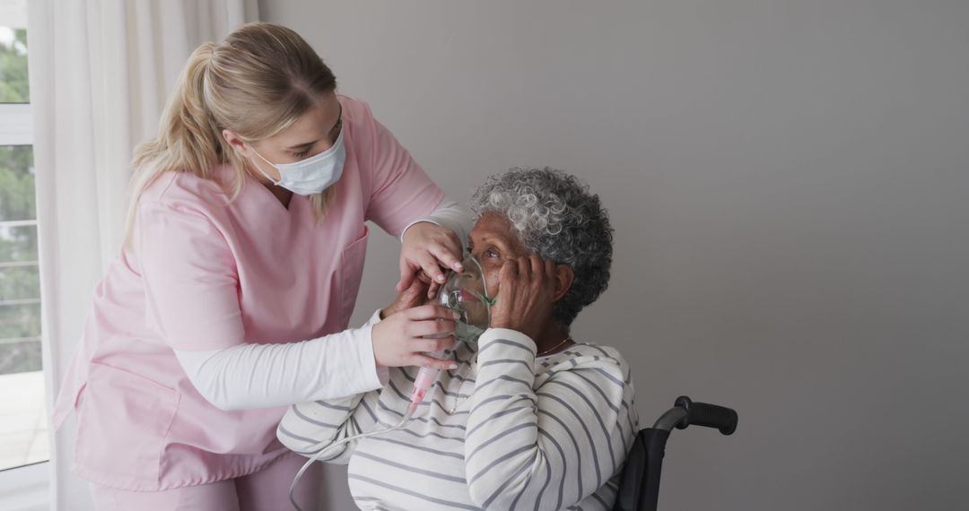 Nurse Assisting Elderly Woman with Oxygen Mask in Healthcare Facility - Free Images, Stock Photos and Pictures on Pikwizard.com