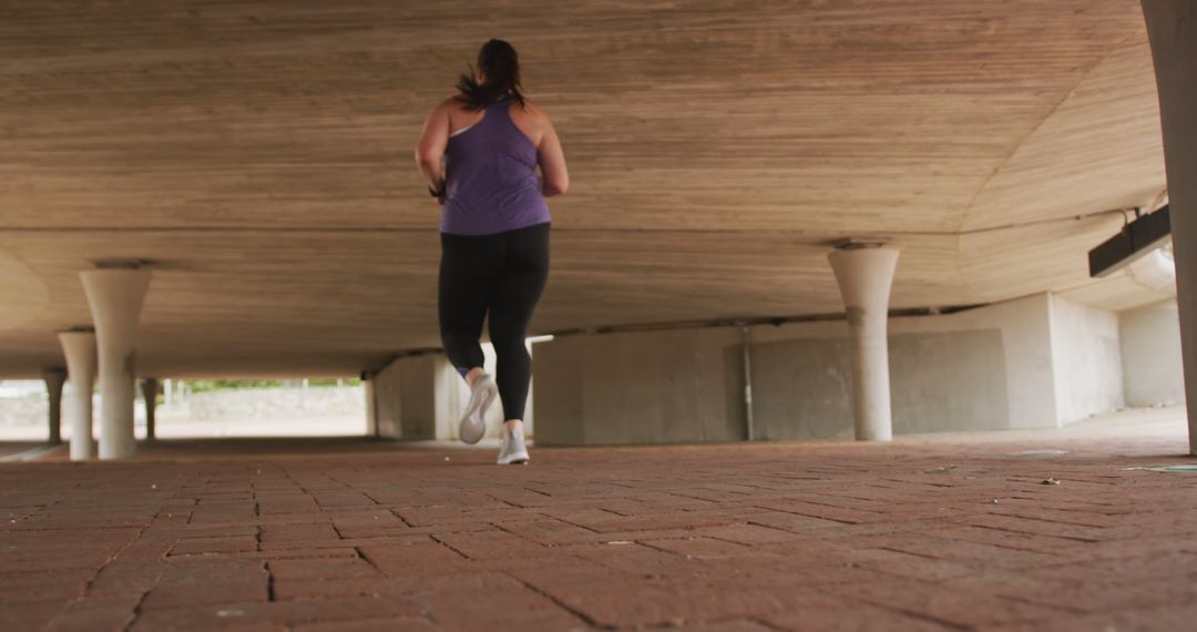 Woman Running Under Overpass in Athletic Clothing - Free Images, Stock Photos and Pictures on Pikwizard.com