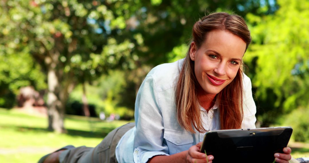 Woman Relaxing in Park Using Tablet - Free Images, Stock Photos and Pictures on Pikwizard.com